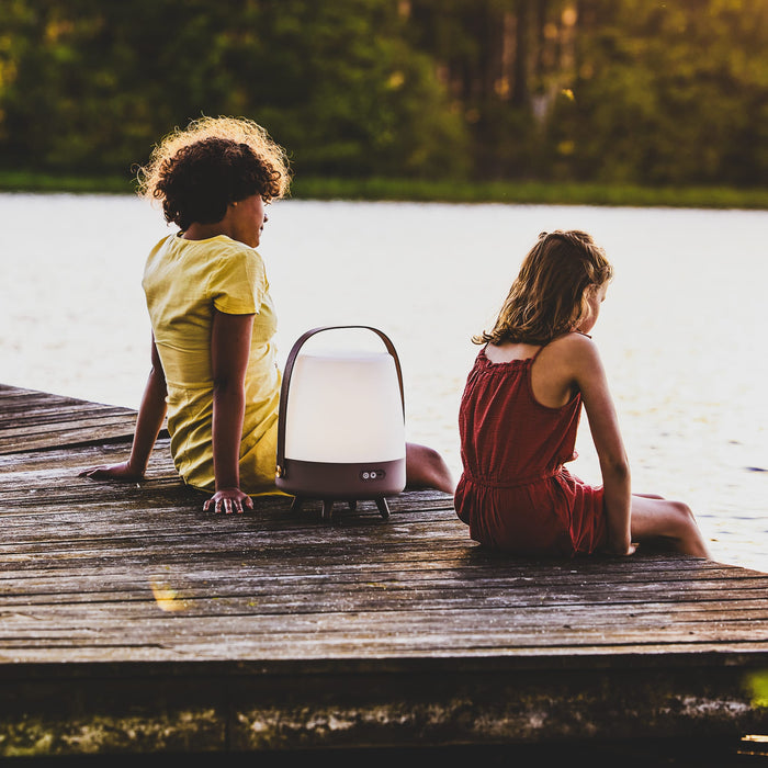 Lite-up Play by Kooduu: Bluetooth-enabled speaker and dimmable LED lamp with elegant wooden legs and a carrying handle.